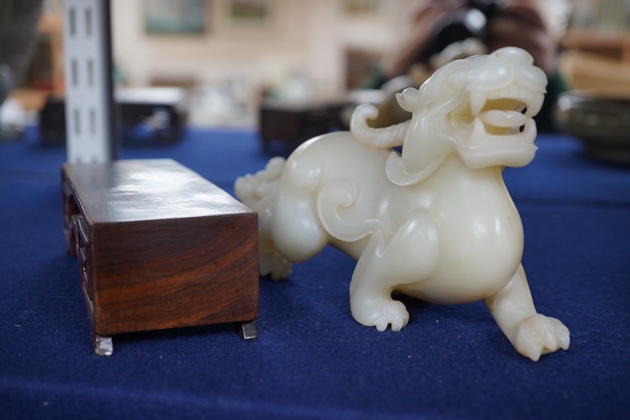 A large Chinese archaistic white jade figure of a mythical beast, hardwood stand, 9cm high, 16cm wide. Condition - good.